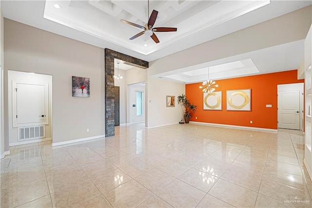 unfurnished room with a tray ceiling and ceiling fan with notable chandelier