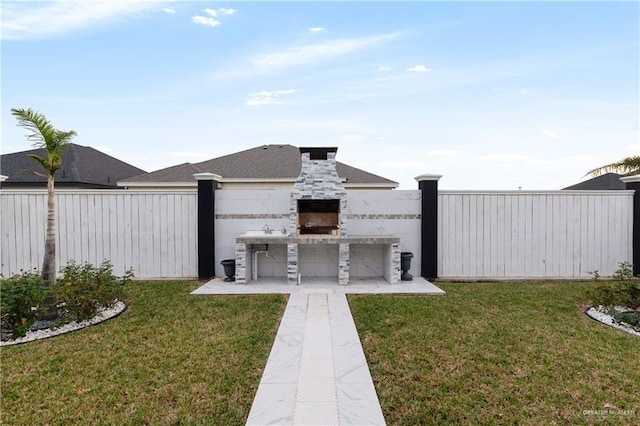 view of yard with a patio and exterior fireplace