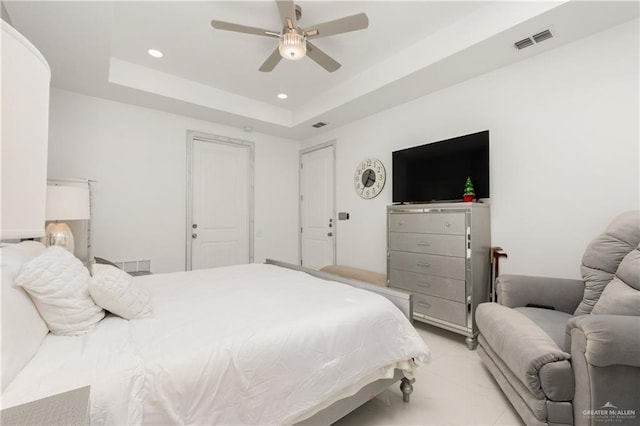 bedroom with ceiling fan and a raised ceiling