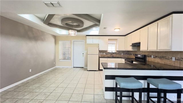 kitchen with decorative backsplash, pendant lighting, black electric range, white fridge, and white cabinetry