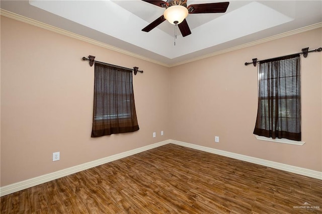 unfurnished room featuring wood-type flooring, a tray ceiling, and crown molding