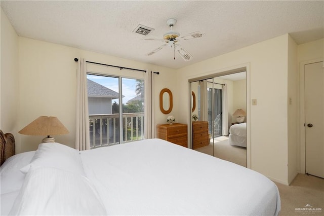 bedroom featuring a closet, visible vents, a ceiling fan, light carpet, and a textured ceiling