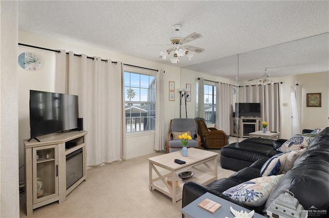 living area with light carpet, a textured ceiling, and a ceiling fan