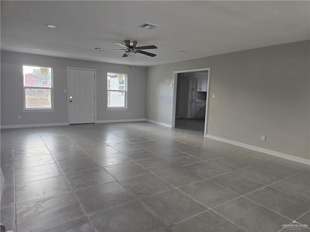 empty room featuring a ceiling fan, baseboards, and visible vents