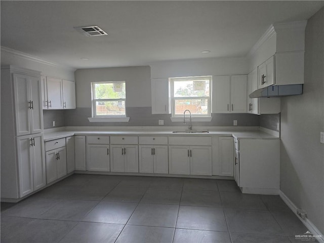 kitchen with visible vents, white cabinets, light countertops, and a sink