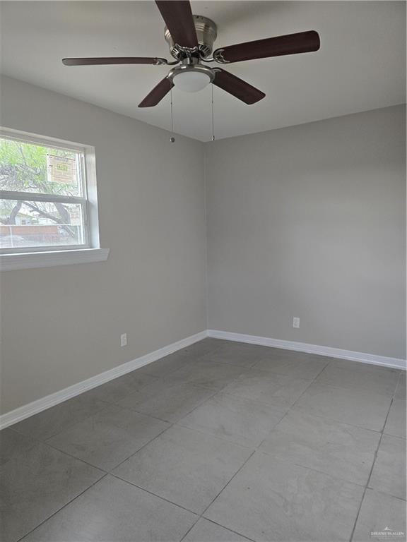 spare room with baseboards and ceiling fan