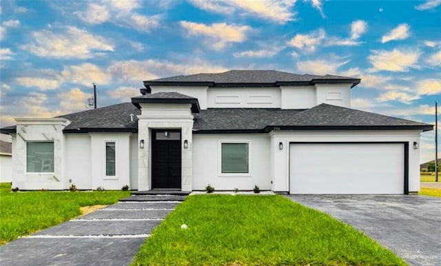 prairie-style home featuring aphalt driveway, stucco siding, an attached garage, roof with shingles, and a front yard