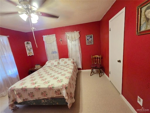 bedroom with ceiling fan, light carpet, and baseboards