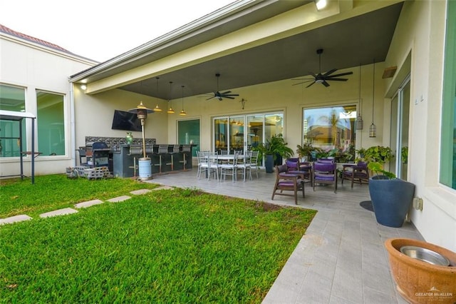 exterior space featuring a patio area, outdoor dining area, a lawn, and stucco siding