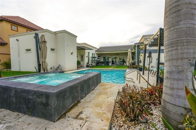 outdoor pool featuring an in ground hot tub and a patio area