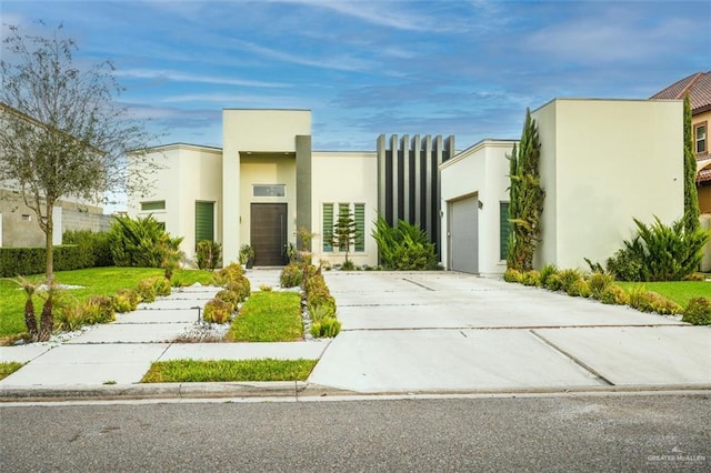 contemporary house with a garage, concrete driveway, and stucco siding