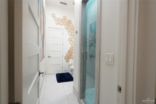 bathroom with visible vents, toilet, tile patterned flooring, a shower stall, and tile walls