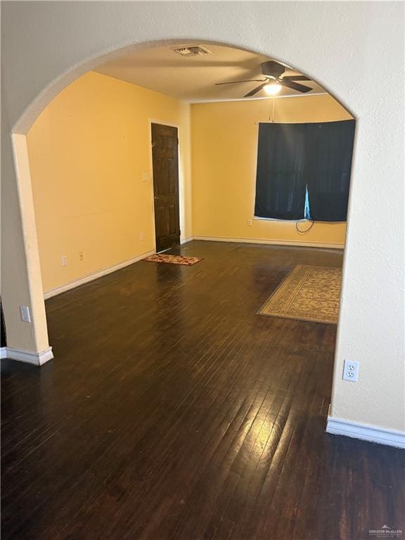 empty room with dark wood-type flooring and ceiling fan