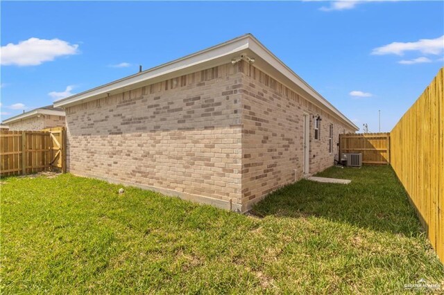 view of home's exterior with a lawn and central AC unit