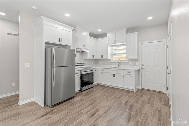 kitchen with sink, white cabinetry, stainless steel appliances, and light hardwood / wood-style flooring