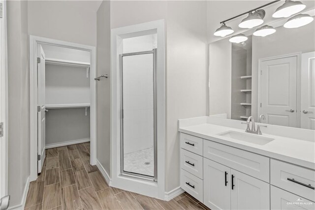 bathroom featuring vanity, wood-type flooring, and a shower with door