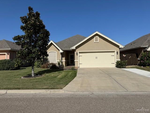 ranch-style home featuring a garage, concrete driveway, a front lawn, and stucco siding