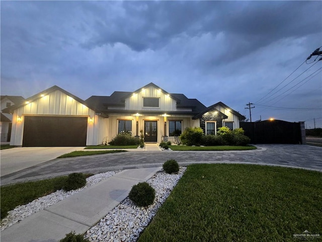 7313 N 25th Ln, Mcallen, TX 78504 - view of front of house with curved driveway, a garage, a front lawn, and board and batten siding