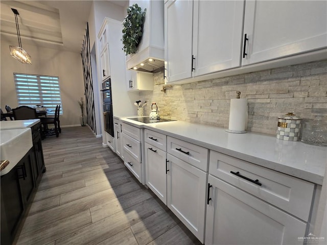 7313 N 25th Ln, Mcallen, TX 78504 - kitchen with light countertops, white cabinetry, custom exhaust hood, and black appliances
