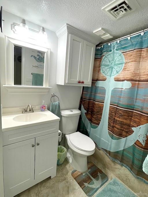 bathroom with walk in shower, vanity, a textured ceiling, and toilet