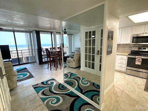 kitchen featuring appliances with stainless steel finishes, backsplash, french doors, ceiling fan, and white cabinets