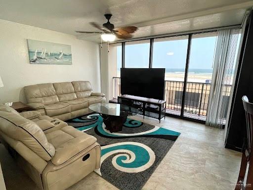 living room featuring ceiling fan and expansive windows