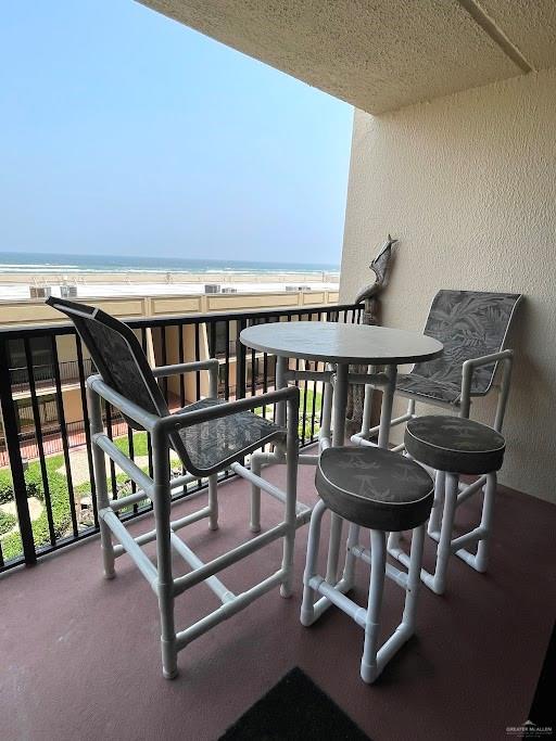 balcony with a water view and a beach view