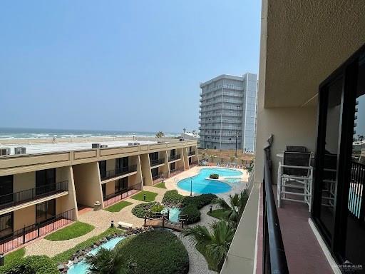 view of pool with a water view and a view of the beach