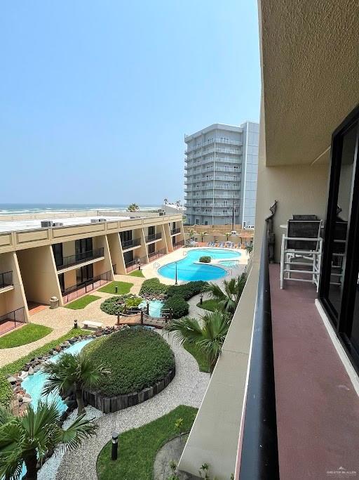 view of pool with a water view and a view of the beach