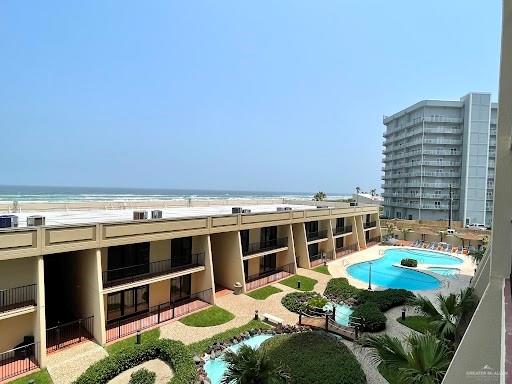 view of swimming pool featuring a water view and a beach view