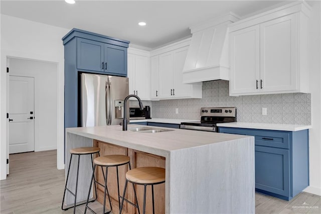 2117 Zinnia St, Weslaco, TX 78596 - kitchen featuring stainless steel appliances, premium range hood, backsplash, a kitchen bar, and blue cabinets