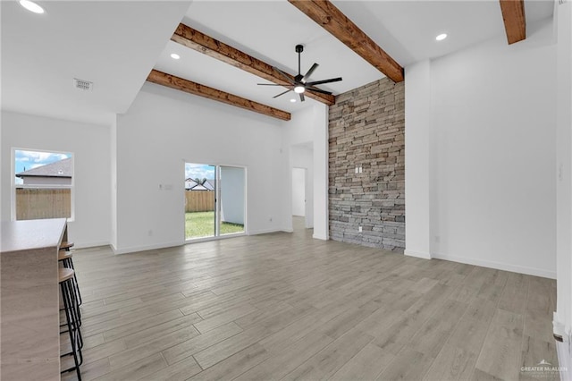 2117 Zinnia St, Weslaco, TX 78596 - unfurnished living room with ceiling fan, healthy amount of natural light, light wood-type flooring, beam ceiling, and a towering ceiling