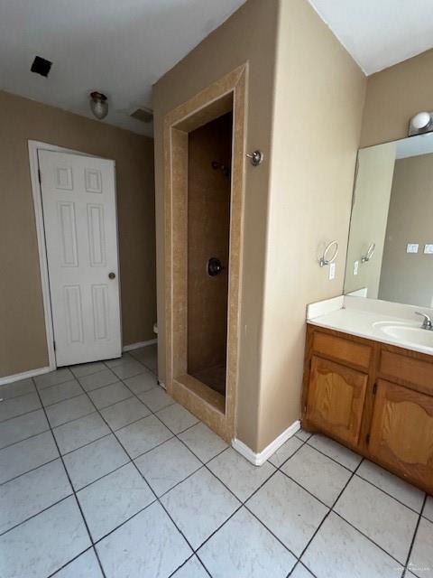 bathroom featuring a tile shower, vanity, and tile patterned floors