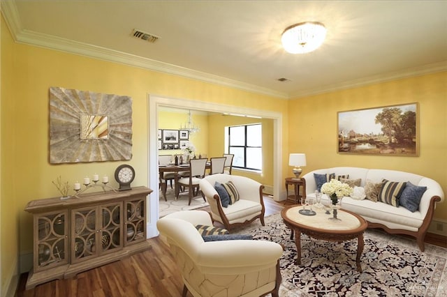 living room with hardwood / wood-style floors, ornamental molding, and a notable chandelier