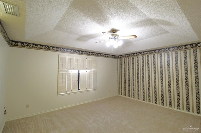 carpeted spare room featuring ceiling fan and a textured ceiling