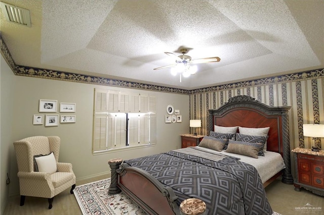 carpeted bedroom featuring a textured ceiling, a raised ceiling, and ceiling fan