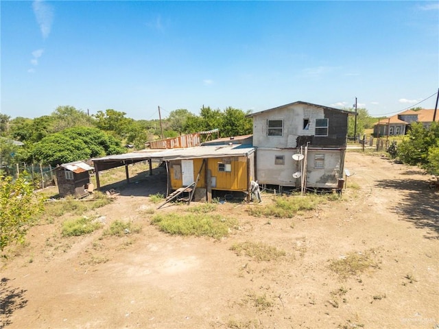 back of property featuring an outbuilding