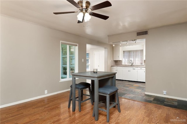 1821 Palm Blvd, Brownsville, TX 78520 - dining room with rail lighting, ceiling fan, baseboards, and dark wood-type flooring