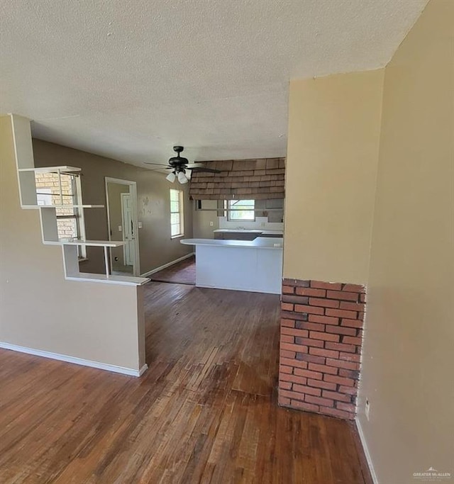 3135 Southmost Rd, Brownsville, TX 78521 - kitchen featuring hardwood / wood-style flooring, ceiling fan, baseboards, a textured ceiling, and a peninsula