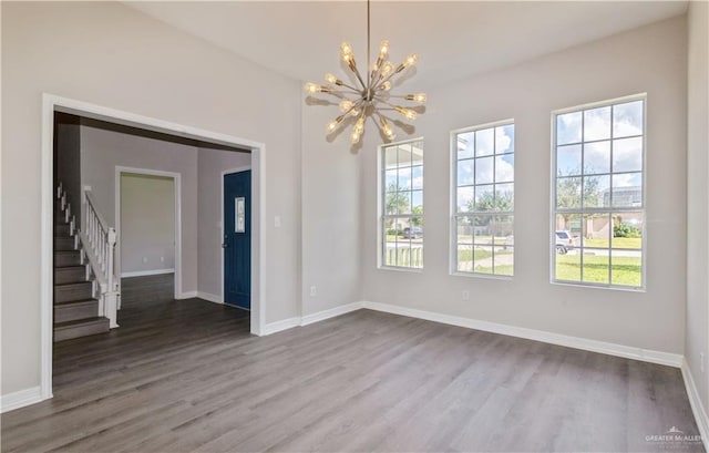 unfurnished room with hardwood / wood-style flooring and a chandelier