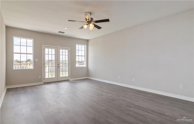 spare room featuring french doors, ceiling fan, and dark wood-type flooring