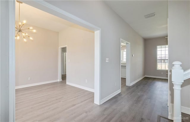 27406 S Kelly Ct, La Feria, TX 78559 - unfurnished room featuring wood finished floors and a chandelier