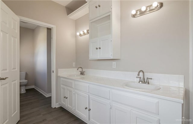 bathroom with toilet, vanity, and hardwood / wood-style flooring