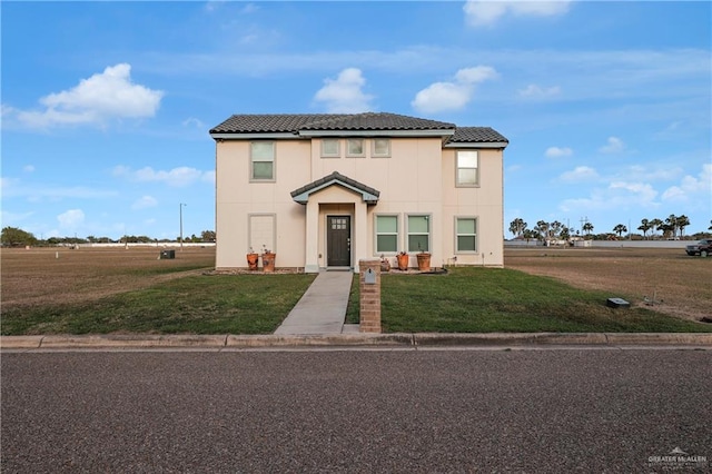 view of front of home with stucco siding, a tiled roof, and a front yard