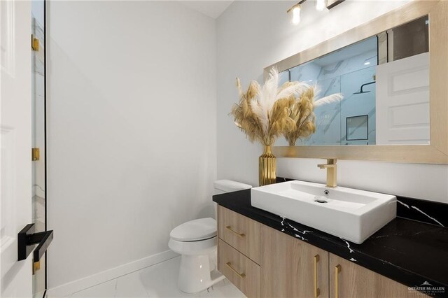 bathroom featuring toilet, vanity, and tile patterned floors