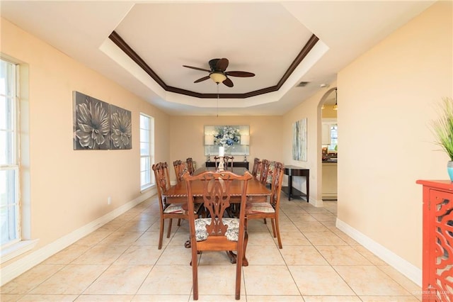 24162 N Tamm Ln, Harlingen, TX 78552 - dining room with a raised ceiling, arched walkways, ceiling fan, ornamental molding, and baseboards