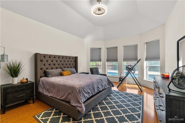 bedroom with lofted ceiling and light hardwood / wood-style flooring