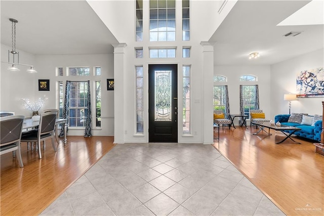 foyer with light hardwood / wood-style floors and ornate columns