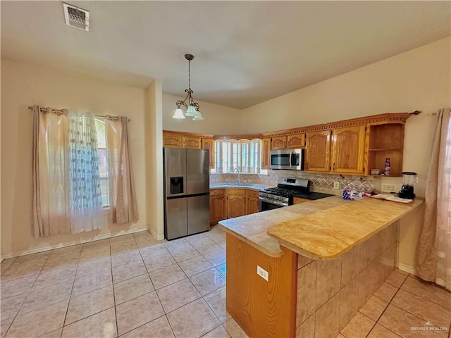 kitchen with kitchen peninsula, stainless steel appliances, hanging light fixtures, and a healthy amount of sunlight