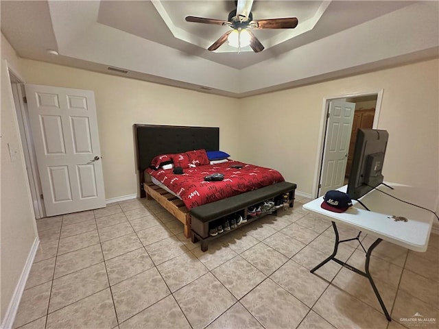 bedroom with tile patterned floors, a raised ceiling, and ceiling fan